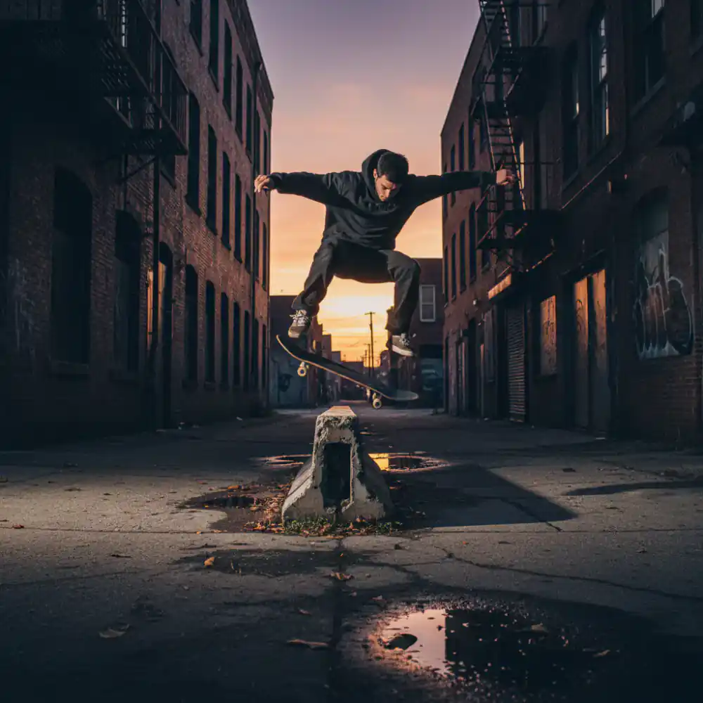 Skateboarder performing a trick over a concrete barrier